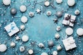 Frame of christmas decoration, gift box, confetti and silver sequins on vintage blue table top view. Flat lay. Party mockup. Royalty Free Stock Photo