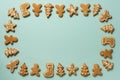 Frame of Christmas gingerbread cookies on blue background with copy space. Pattern of gingerbread men, snowflake, star, fir-tree, Royalty Free Stock Photo
