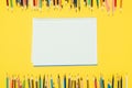Frame of colorful pencils isolated on yellow background with notebook Royalty Free Stock Photo