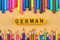 Frame from colorful pencils and word GERMAN written on plastic cubes. Royalty Free Stock Photo