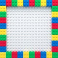 Frame of colorful toy bricks on white construction plate
