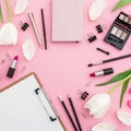 Frame composition with clipboard, tulips, cosmetics and accessory on pink background. Top view. Flat lay. Home feminine desk. Royalty Free Stock Photo