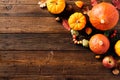 Frame corner of pumpkins, fall leaves, berries, apple on wooden table. Thanksgiving, Halloween, Autumn, Harvest concept. Flat lay Royalty Free Stock Photo