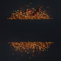 Frame of crushed red cayenne pepper, dried chili flakes and seeds on a black background. Homemade spices ingredients for cooking.