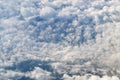Frame of cumulus clouds swirling in center into a funnel, with blue sky peeking through gaps, aerial photograph