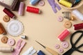Frame of different sewing supplies on beige background, flat lay. Space for text Royalty Free Stock Photo