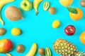 Frame from Different Tropical and Seasonal Summer Fruits. Pineapple Mango Coconut Citrus Orange Lemons Apples Kiwi Bananas on Blue Royalty Free Stock Photo