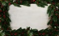 Frame done of green fir branches and red berries with empty white background as festive table ornament for Hanukkah or Christmas