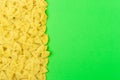 Frame from farfalle type of pasta on green background with space for text Royalty Free Stock Photo