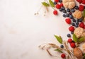 Frame of fresh ripe rowan berries and green leaves on white wooden table, flat lay. Space for text