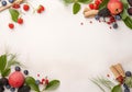 Frame of fresh ripe rowan berries and green leaves on white wooden table, flat lay. Space for text