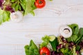 A frame of fresh vegetables, lettuce, tomato, cucumber, mushrooms, parsley, spinach on a white wooden background. Royalty Free Stock Photo