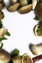 Frame of freshly picked forest mushrooms on white background, top view. Compositiof dry maple leafs, ceps, and dry orange slices A Royalty Free Stock Photo