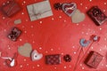 Frame of gifts, hearts and other love objects on red background. Valentine`s day concept