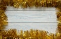 Frame of golden Christmas garland. Wooden white background.