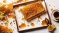 Frame with honeycomb, plate with honey and honey stick close up on white background. Royalty Free Stock Photo