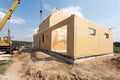 Frame house construction. View on new building with crane against blue sky. Royalty Free Stock Photo