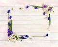 Frame of hyacinths Hyacinthus, muscari and blossom cherry tree on a white wooden background with space for text. Top view