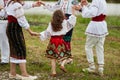 Frame image of a family with kids in traditional romanian clothes, dancing outside. Royalty Free Stock Photo