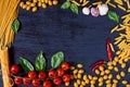 Frame of Italian traditional food, spices and ingredients for cooking as basil, cherry tomatoes, garlic and various pasta