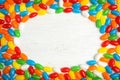 Frame of jelly beans on light background, top view