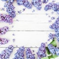Frame of lilac flowers branches on wooden background. Flat lay, top view. Royalty Free Stock Photo