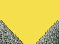 Frame in lower corners ultimate gray sea pebbles shadow,illuminating yellow background.Rectangular copy space.Close up Royalty Free Stock Photo