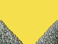 Frame in lower corners ultimate gray sea pebbles with shadow,illuminating yellow on background.Summer vacation concept.Rectangular Royalty Free Stock Photo