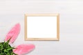 Frame lying on a white wooden background, rabbit ears, a flower pot with artificial green grass. Easter concept. Copy space Royalty Free Stock Photo