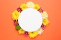 Frame made of beautiful chrysanthemum flowers and blank card on orange background, flat lay. Space for text Royalty Free Stock Photo