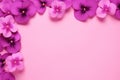 Frame made of beautiful purple pansy flowers on light pink background with copy space. Royalty Free Stock Photo
