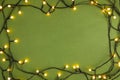 Frame made with Christmas lights on green background