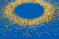 Frame made of colored confetti. Blue background. Royalty Free Stock Photo