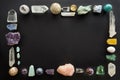 Frame made of crystal stones on black background. Colorful gemstones and crystals on dark background with copy space. Royalty Free Stock Photo