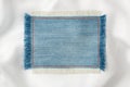 Frame made of denim fabric with yellow stitching on white silk Royalty Free Stock Photo