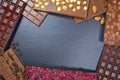 A frame made from different sorts of chocolate on a black slate plate with space for text Royalty Free Stock Photo