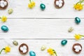 Frame made of easter eggs, spring flowers and feathers on white wooden background. easter composition Royalty Free Stock Photo