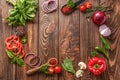 Frame made of fresh aromatic herbs, spices and vegetables on wooden background Royalty Free Stock Photo