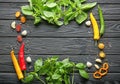 Frame made with fresh basil, spices and vegetables on wooden background Royalty Free Stock Photo