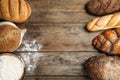 Frame made with fresh bread on wooden background, flat lay. Royalty Free Stock Photo