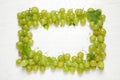 Frame made with fresh ripe juicy grapes on white wooden table Royalty Free Stock Photo