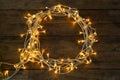 Frame made of glowing Christmas on wooden background, top view. Space for text Royalty Free Stock Photo