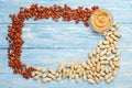 Frame made of nuts peanuts in shell, peeled peanuts, peanut butter in glass plate with copy space in the center on blue wooden Royalty Free Stock Photo