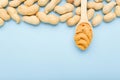 Frame made of nuts peanuts in shell and wooden spoon with creamy peanut butter with copy space on blue colored background. Flat Royalty Free Stock Photo