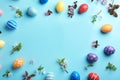 Frame made of painted Easter eggs and blossoming branches on color background, top view. Royalty Free Stock Photo