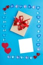 In a frame made of pebbles of hearts on a blue background  a box with a bow. Copy the place Royalty Free Stock Photo