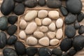 Frame made of rope lying on the sand among the black and white stones Royalty Free Stock Photo