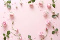 Frame made of rose flowers, petals and heart shaped confetti on light pink background. Floral composition Royalty Free Stock Photo
