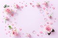 Frame made of rose flowers, petals and heart shaped confetti on light pink background. Floral composition Royalty Free Stock Photo