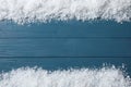 Frame made of snow on blue wooden background, top view. Christmas time Royalty Free Stock Photo